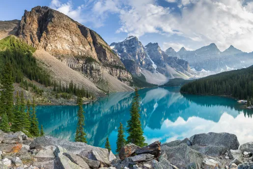 Large lake surrounded by large boulders and mountains in the background