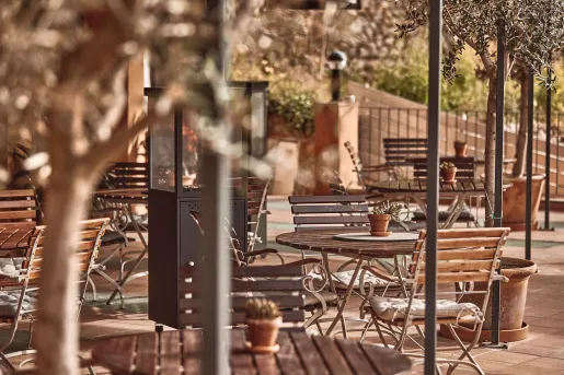Outdoor patio with circular, wooden tables and chairs