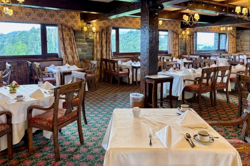 Restaurant dining area with square tables and wooden chairs