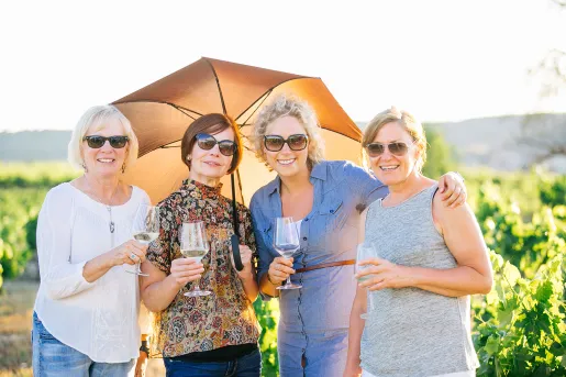 4 women wine tasting and holding an umbrella in Spain.