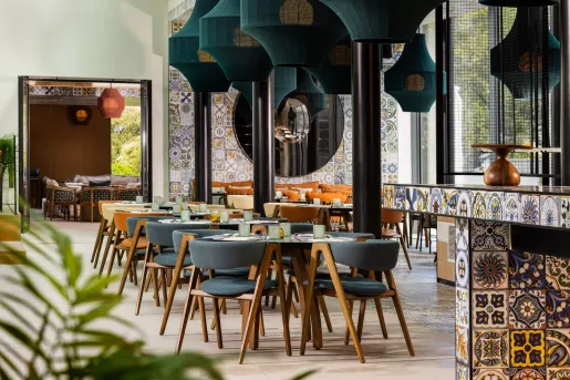 Dining area with gray, cushioned chairs surrounding circular dining tables