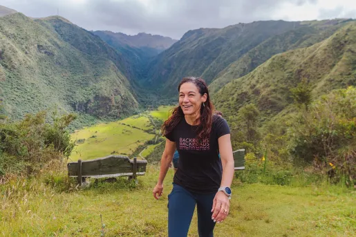 Woman smiling while ascending on a grassy hill