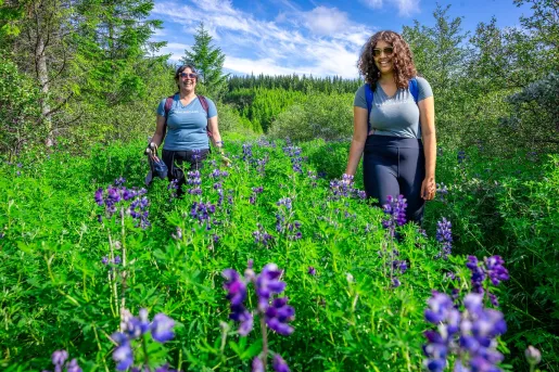 Two women smiling, while walking through a garden