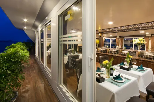 Cruise ship restaurant with white dining tables and large windows