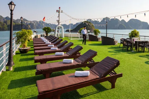Cruise ship patio with turf lawn on top and rows of wooden chairs