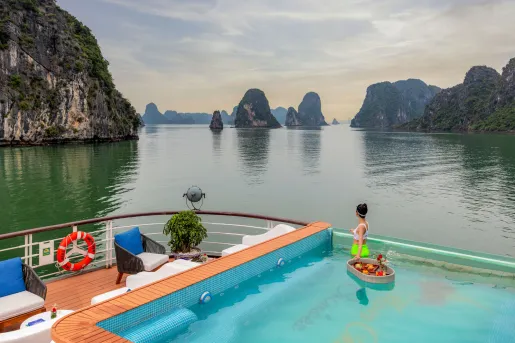 Cruise ship with a pool on the top, looking out towards a large lake
