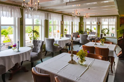Restaurant dining area with white tables and wooden chair