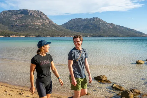 Man and woman smiling while walking on a beach