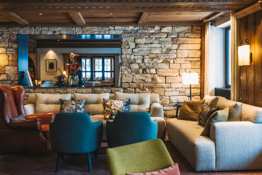 Lounge with cushioned seats and an exposed brick wall in the background