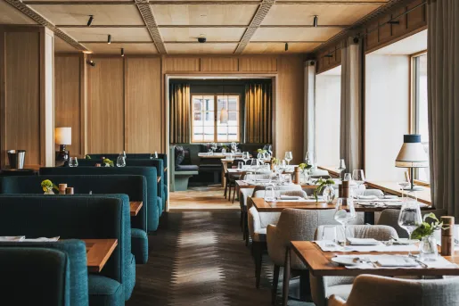 Restaurant dining area with blue, cushioned sofas and large windows