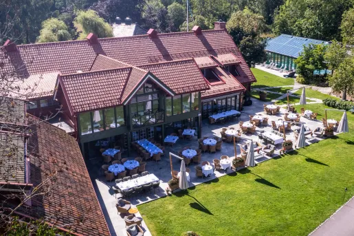 Exterior, sky view of brown hotel building with large windows and outdoor patios surrounding