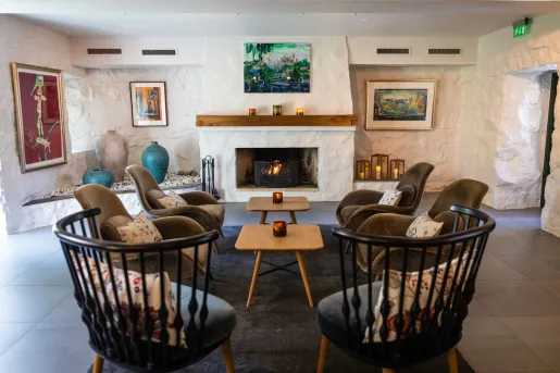 Large, black chairs surrounding smaller, wood coffee tables