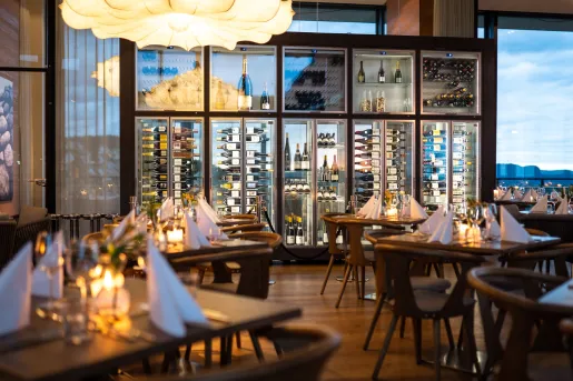 Restaurant with wooden dining tables and chairs, with folded handkerchiefs on each table