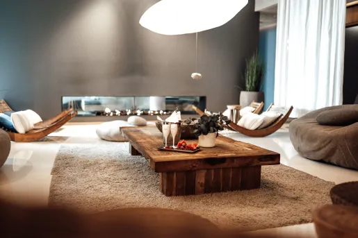 Lounge area with a wooden coffee table in the center, with fruits and champagne glasses