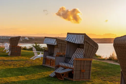 Beach chairs at Memmo Baleeira Hotel in Sagres, Portugal features a reclining wicker design with striped cushions.