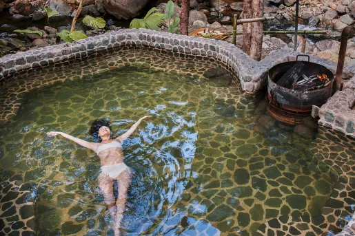 Woman in a pool with her arms wide open