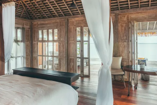 Hotel room with white bed and long-white sheets