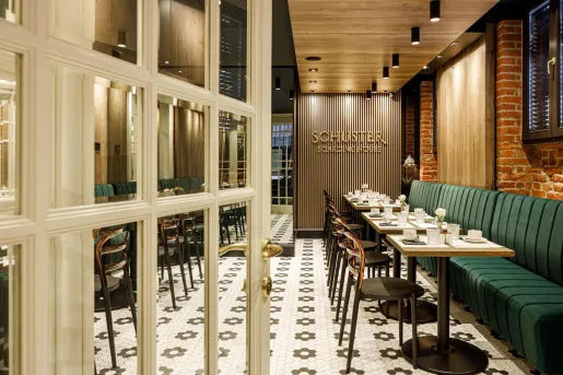 Restaurant dining area with checkered flooring and green booths