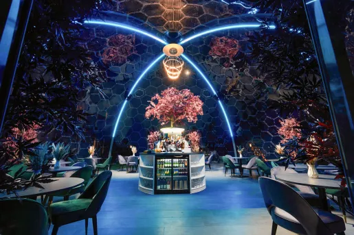 Large dome-shaped restaurant with plants and neon lights