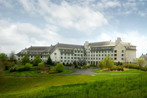 White, castle-like hotel building on a grassy hill