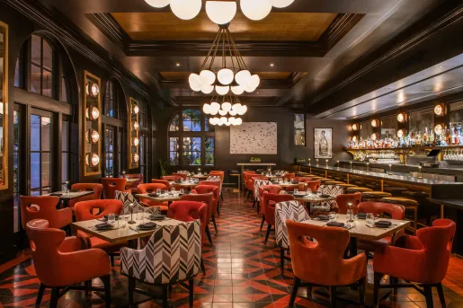 The restaurant Hotel Californian in Santa Barbara, features red and black tiled floors, red chairs and chandeliers.
