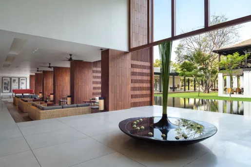 Walkway in a building, with stone flooring and a large fountain