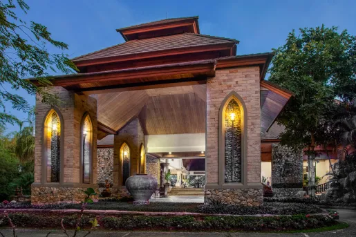 Exterior hotel entrance with large stone pillars and warm lights