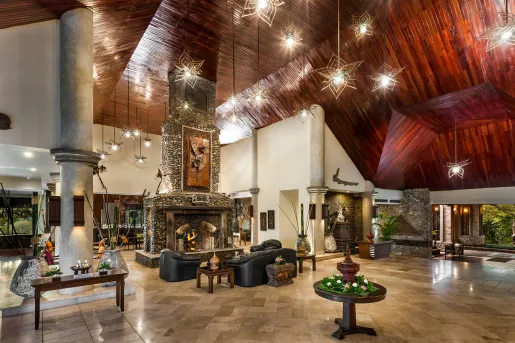 Large, open hotel lobby with dark brown ceilings and marble flooring