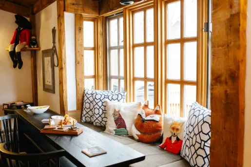 A cozy nook with wood-framed windows and an assortment of pillows at the Rabbit Hill Inn in Vermont.