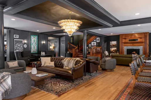 Lobby of The Wentworth Inn in Jackson, New Hampshire, featuring a large brown leather sofa and a distinctive crystal chandelier