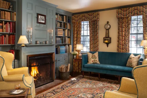 Living room area with blue and beige couches in front of a fireplace