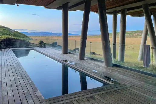 Outdoor pool under a bridge, with a large valley in the background