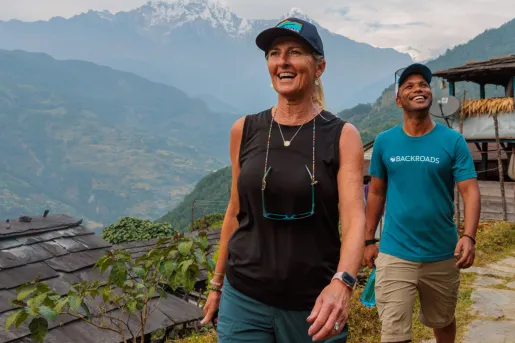 Man and woman smiling while walking on a dirt trail