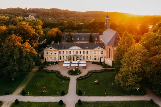 Exterior, sky view of a large building with a trimmed lawn and cement pathways