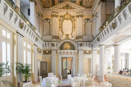 Cathedral-style restaurant dining area with white chairs and dining tables