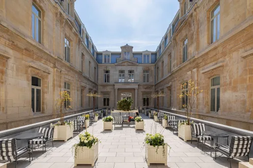 Outdoor patio area in between two large, stone buildings
