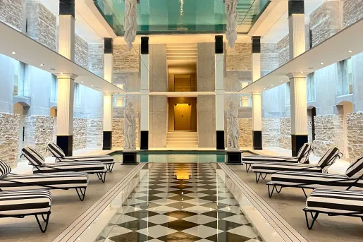 Spa room with checkered, tile floorings, striped reclining chairs and a hot tub in front