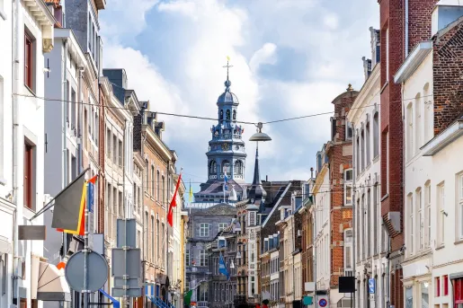 Main avenue of a rustic town with a large church in the distance
