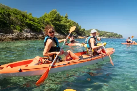 Two women kayaking and smiling at the camera