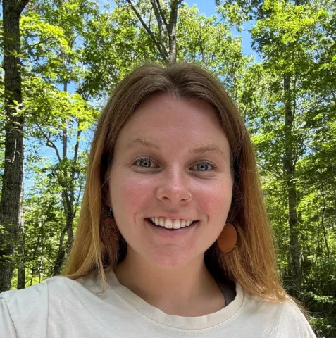Woman smiling with a forest in the background