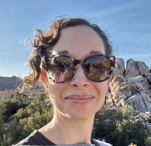 Woman smiling, wearing sunglasses