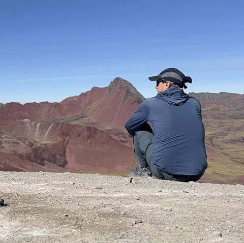 Backroads leader on cliff overlooking mountains