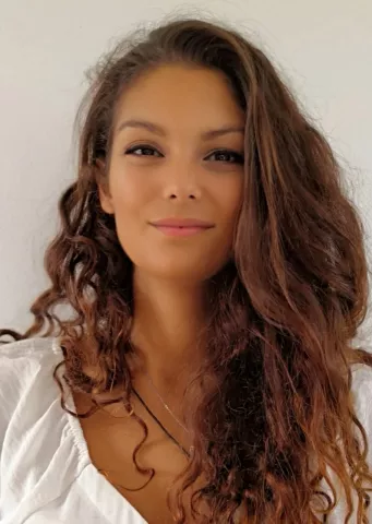 Woman smiling, with light brown hair and a white shirt
