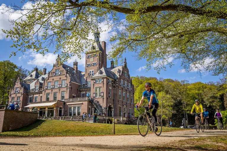 guests biking past beautiful building
