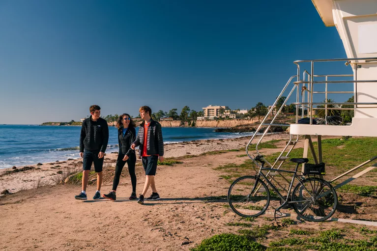 People walking along California beach.