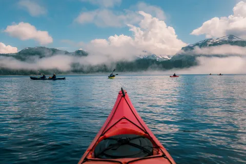 POV shot of guest kayaking, large lake, other guests, clouds etc.