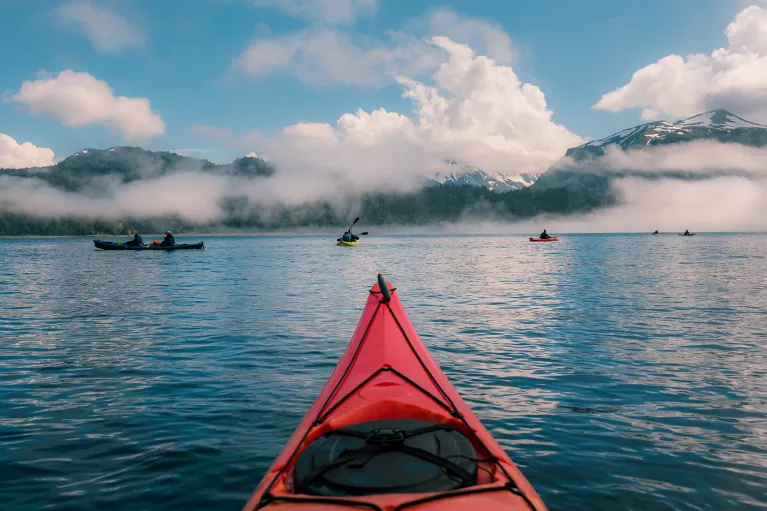 POV shot of guest kayaking, large lake, other guests, clouds etc.