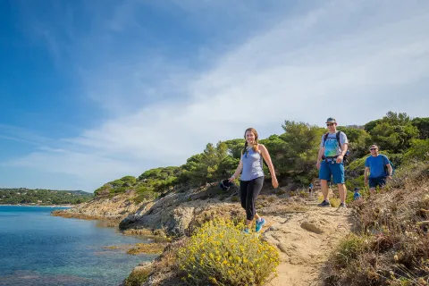 Group of three Backroads guests hiking beside the sea in France