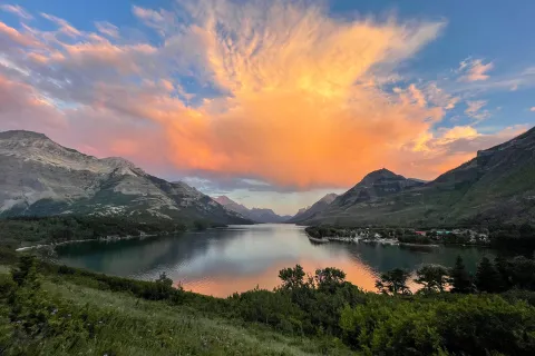 Orange sunset over lake and mountains