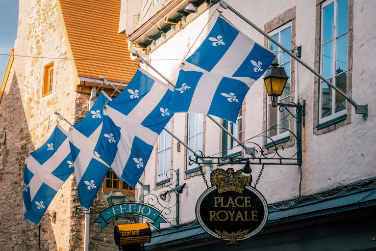 Storefront shot of "PLACE ROYALE", Quebec flags proudly displayed.